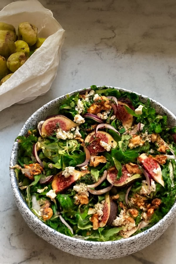Ein Teller mit einem Salat aus Feldsalat, Zwiebeln, Walnüssen und Ziegenkäse