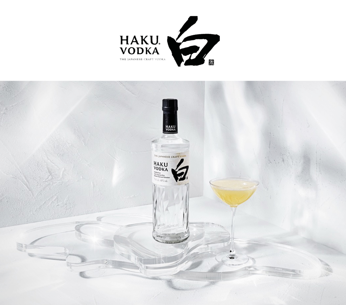 Haku Vodka Flasche mit Haku Yuzu Martini im Glas vor weißem Hintergrund